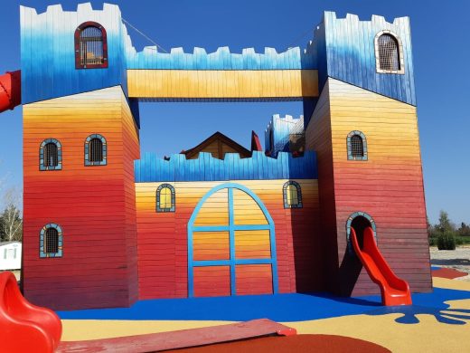 Aire de jeux château avec toboggans sur sol amortissant coloré