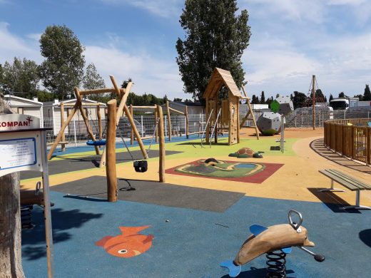 Aire de jeux en robinier sur sol souple coloré dans un camping