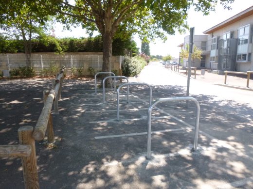 Arceaux vélo et barrière en rondins dans un espace public