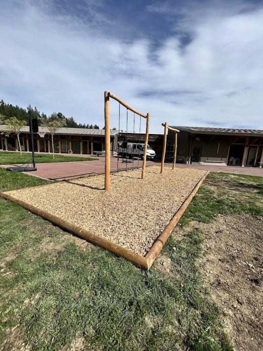 Balançoire en bois sur gravier dans une école maternelle