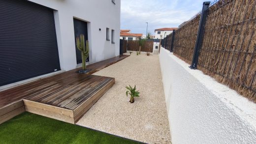 Jardin fermé par un brise-vue en bruyère, terrasse en bois