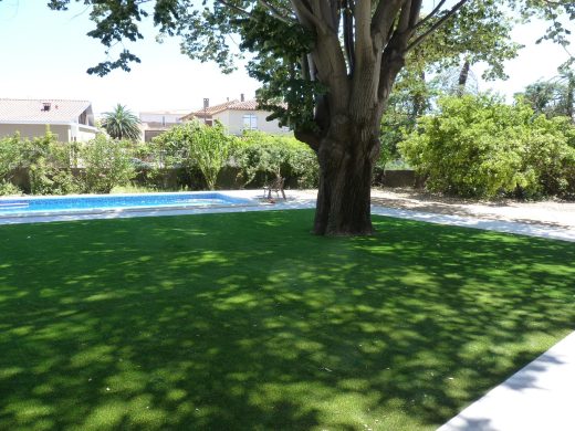 Grand jardin en gazon synthétique autour d’une piscine