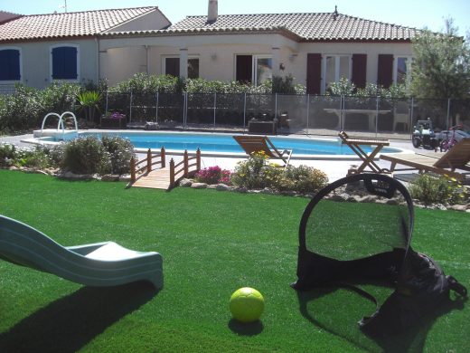 Jardin en gazon synthétique avec massifs et piscine