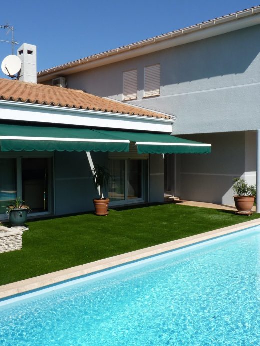 Gazon synthétique autour de la piscine d’une maison