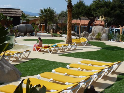 Plage de piscine en gazon synthétique avec transats