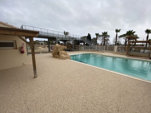 Moquette de pierre autour de la piscine du camping Les Tamaris