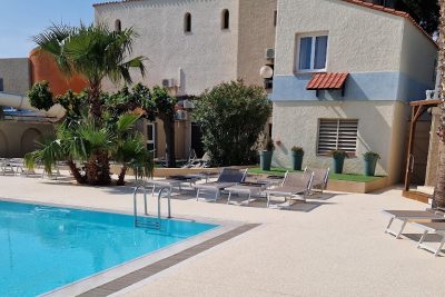 Plage de piscine en moquette de pierre avec transats