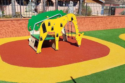 Jeu girafe sur un sol amortissant coulé rouge et jaune, entouré de gazon synthétique